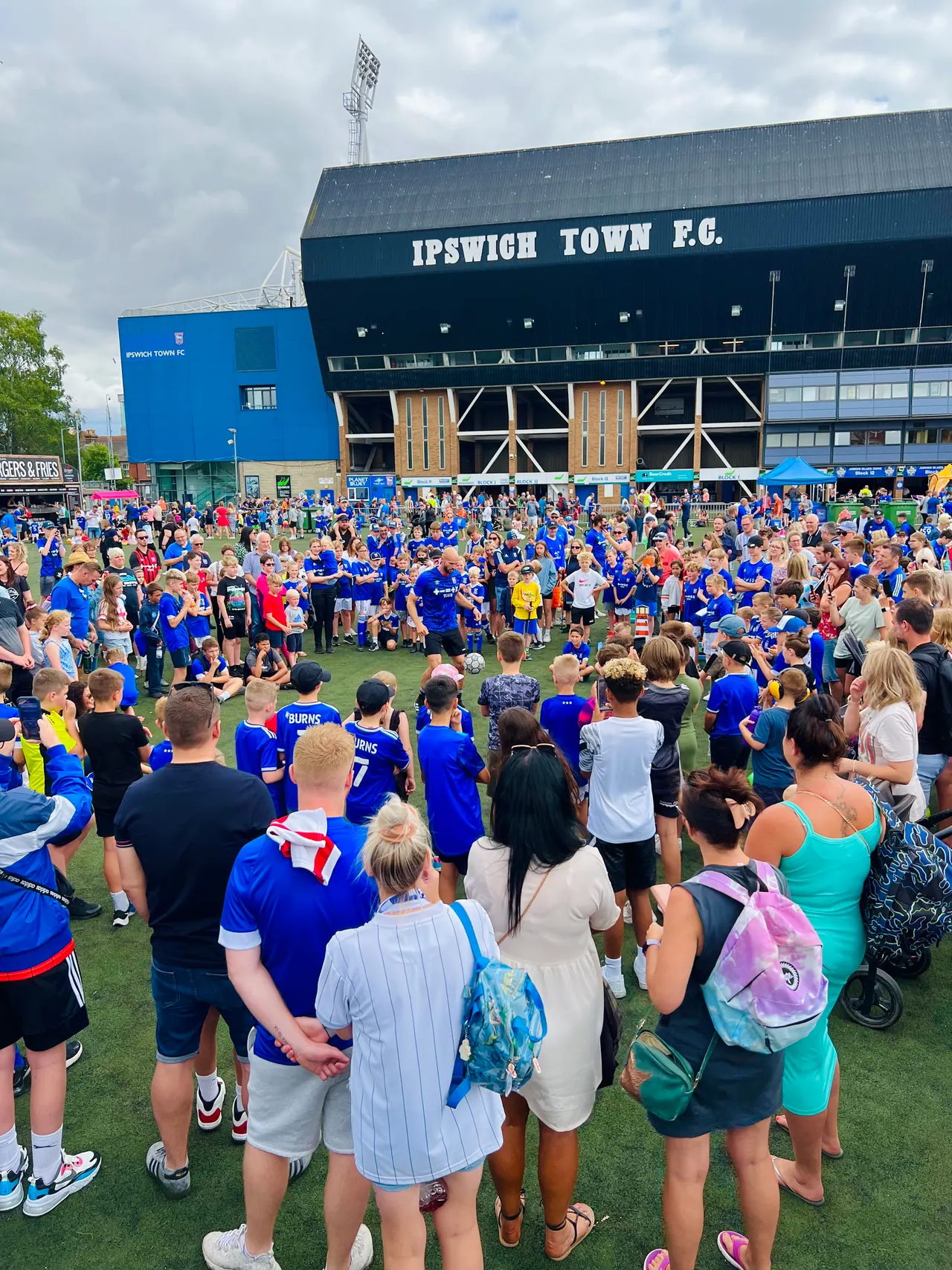 Daniel at a football event with a crowd of young fans
